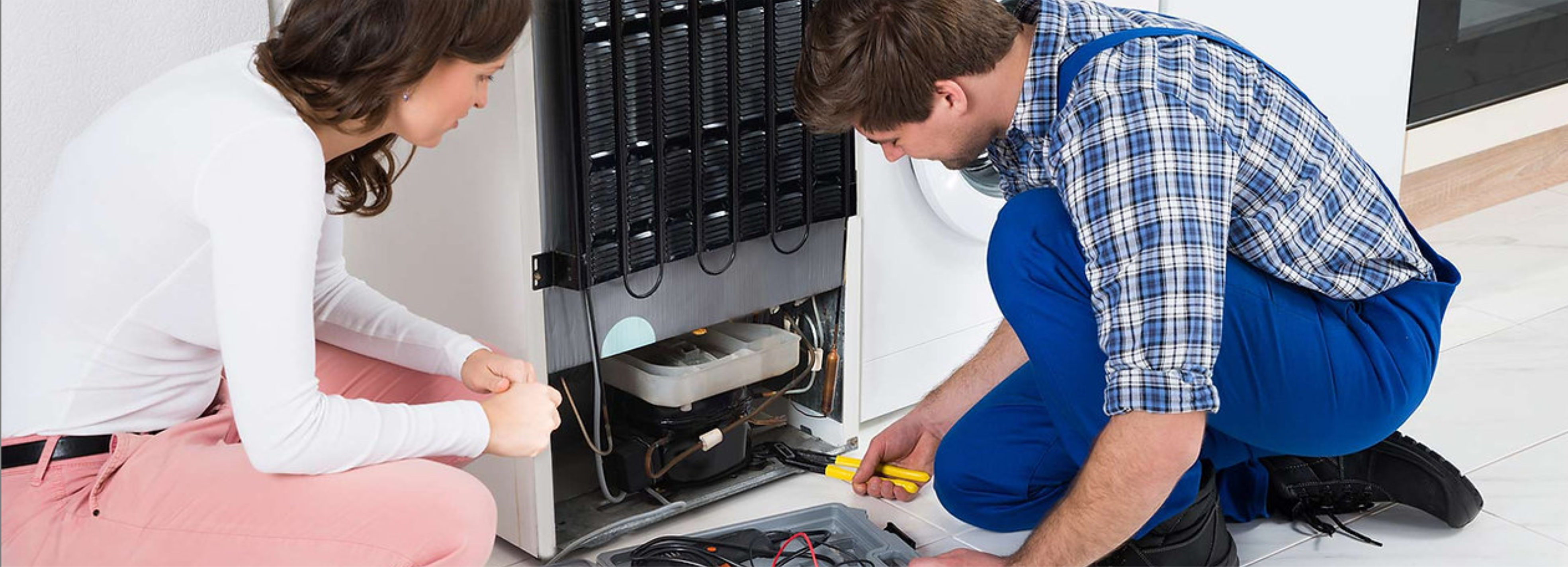 Técnico consertando geladeira